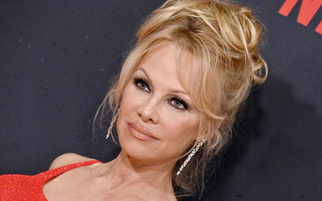 The Secret to Pamela Anderson’s Prolific Updo Is a G-String — Watch the Video